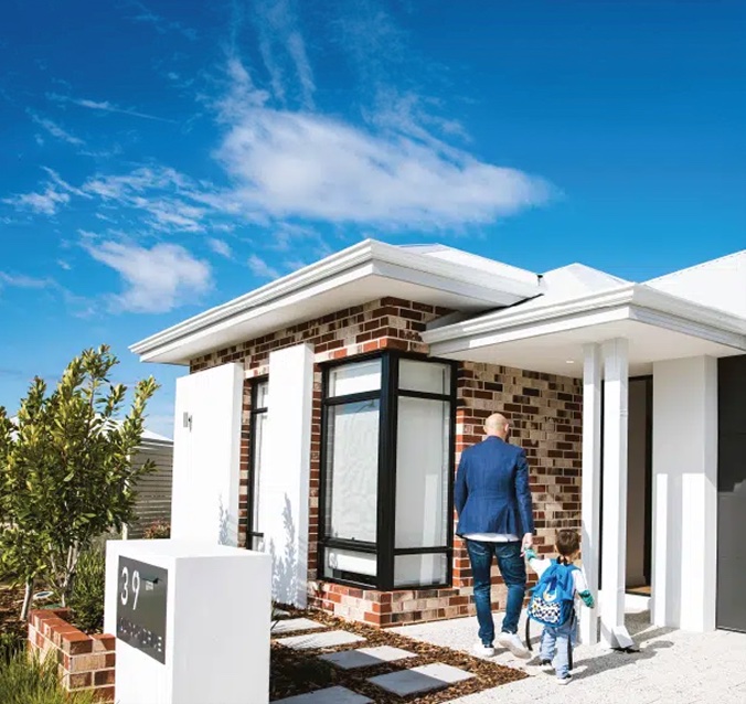 Father and child walking up to a new brick home